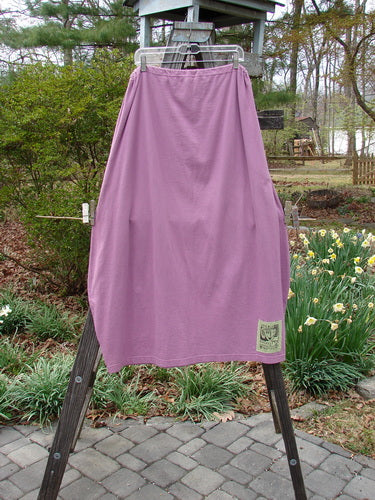 1997 Big Pocket Skirt Abstracts Crocus Size 1 hanging on a clothesline, showcasing its unique bell-shaped bottom, drawstring waist, and giant exterior pocket with a vintage button closure.