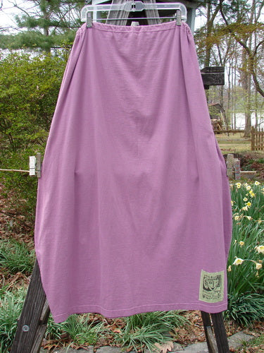1997 Big Pocket Skirt Abstracts Crocus Size 1 hanging on a clothesline, showcasing its unique bell-shaped bottom and large exterior pocket with a vintage button closure.