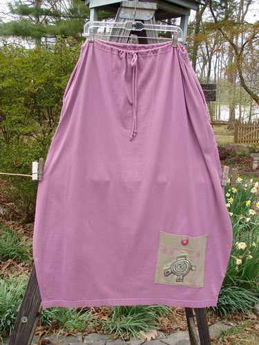 1997 Big Pocket Skirt Abstracts Crocus Size 1, featuring a drawstring waist, bell-shaped bottom, and a prominent lower exterior pocket, hanging on a clothesline against an outdoor backdrop.