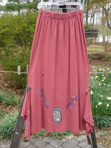 1996 Dubuffet Skirt Abstract Ember Size 2 features a long, pleated design with diamond-shaped side panels and removable flutters, hanging on a clothesline.