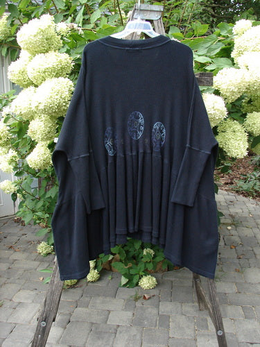 1997 Thermal Bungalow Jacket Celtic Medallion Cast Iron OSFA displayed on a wooden ladder, showcasing its loose fit, three medallion appliqués, and gathered lower half. A classic vintage piece from BlueFishFinder.com.
