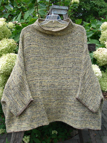 Barclay Alpaca Big Square Mock Collar Sweater Marled Sun OSFA, a loose-fitting, poncho-style knit with a cowl neck and wide sleeves, is displayed on a wooden ladder amidst flowering shrubs.