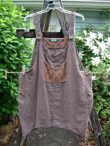 Barclay Linen Adjustable Snap Apron Jumper Playful Chirp Mocha Size 2, featuring adjustable shoulder straps, multiple metal snaps, pocketed upper bib, dual side wrap pockets, and a playful birdie theme.