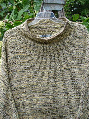 Barclay Alpaca Big Square Mock Collar Sweater Marled Sun OSFA draped on a hanger, showcasing its loose-knit texture, mock turtleneck, dolman shoulders, and three-quarter sleeves against lush foliage.