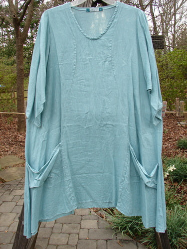 Barclay Linen Side Pocket Tab Tunic Dress Unpainted Mint Size 2 hanging on a clothesline, showcasing its oval neckline, curved seams, wider short sleeves, and two front pockets.