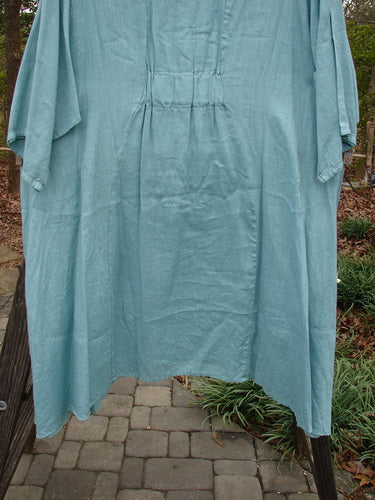Barclay Linen Side Pocket Tab Tunic Dress Unpainted Mint Size 2 hanging on a clothesline, showcasing its slightly scooped oval neckline, widening shape, and two drop flop pockets.