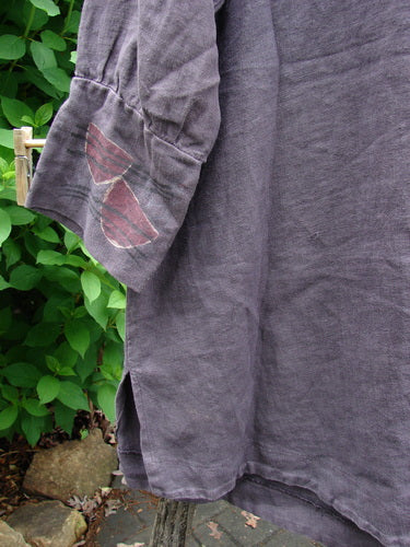 The Barclay Linen Metal Button Drop Pocket Jacket in Floral Reach Brum Size 2 features long billowy sleeves, metal buttons, elastic loop closures, and double drop front pockets with a unique painted floral design.