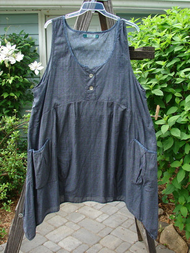 Barclay Tuesday's Pocket Prairie Dress Contrast Unpainted Grey Floral Size 2 hangs on a clothes rack, showcasing its light weight organic summer cotton fabric, widening hemline, and exterior pleated pockets.