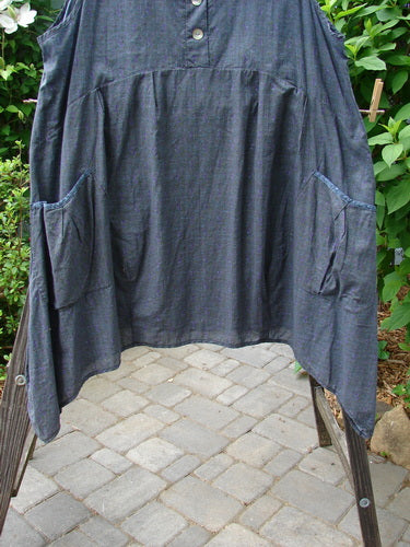 Barclay Tuesday's Pocket Prairie Dress Contrast Unpainted Grey Floral Size 2 displayed on a clothes rack, showcasing its unique pleated empire waist, diagonal pockets, and shell-like buttons.