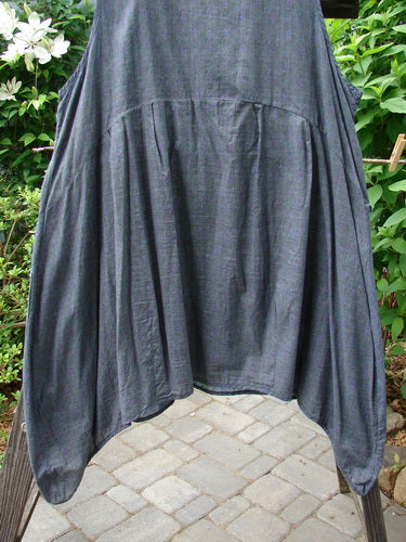 Barclay Tuesday's Pocket Prairie Dress Contrast Unpainted Grey Floral Size 2 hanging on a clothesline, showcasing its detailed pleated pockets, shell-like buttons, and varying hemline.