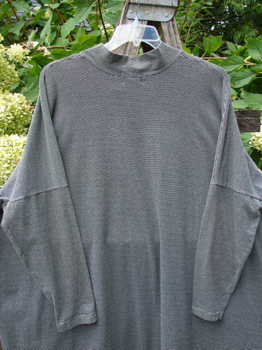 1999 Cotton Lycra Square Mock Pullover Unpainted Black Stripe Size 2, featuring a long-sleeved, oversized design with dolman drop shoulders and a stand-up mock turtleneck, photographed outdoors against green foliage.