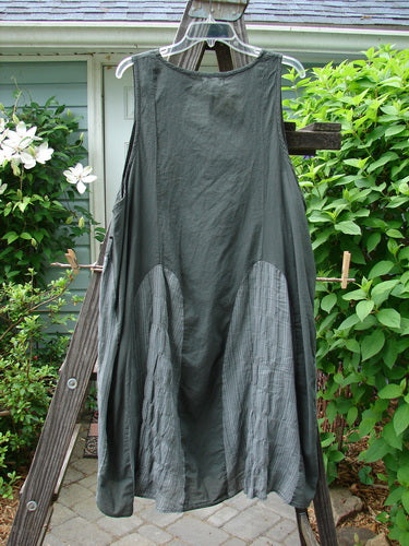 Barclay NWT Batiste Carousel Shift Jumper Unpainted Stripe Slate Size 2 hanging on a clothesline, showcasing its oval neckline, side cord drawstrings, and flowing A-line hem against an outdoor backdrop.