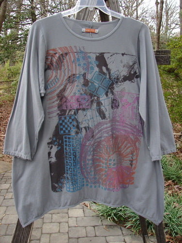 Barclay Long Sleeved Dip Side A Lined Tunic Daisy Logo Grey Storm Size 1, featuring a graphic daisy design, three-quarter sleeves, and a rounded neckline, displayed in perfect condition.