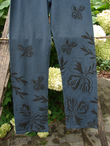 Barclay NWT Cotton Lycra Straight Pant Botanicals Lux Silhouette Size 1, featuring a black floral print, thinner elastic waistband, longer wide lowers, and full lower leg botanicals theme, hanging outdoors.