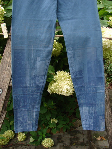 Barclay NWT Cotton Lycra Legging Light Scribe Echo Blue Size 1 hangs outdoors on a wooden ladder, showcasing its slim fit and full elastic waistband with tapering lowers against a lush green backdrop.