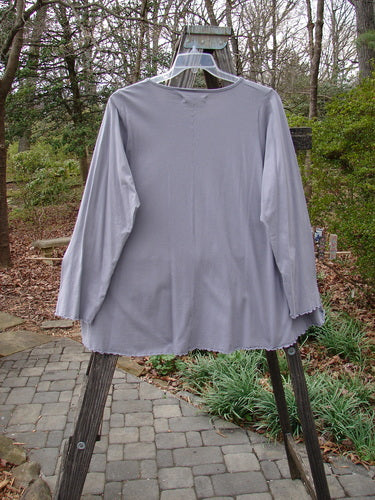 Barclay Long Sleeved Cafe Tee Story Script Grey Storm Size 1 on a hanger, showcasing a rounded neckline, long sleeves, and a swinging rounded A-line shape with curled edgings.