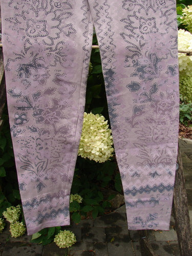 Barclay NWT Cotton Lycra Basic Legging Tiny Botanicals Sea Fog Size 1, showcasing an intricate floral/paisley print with a slimming fit, elastic waistband, and tapered legs, hung outdoors against garden paving.