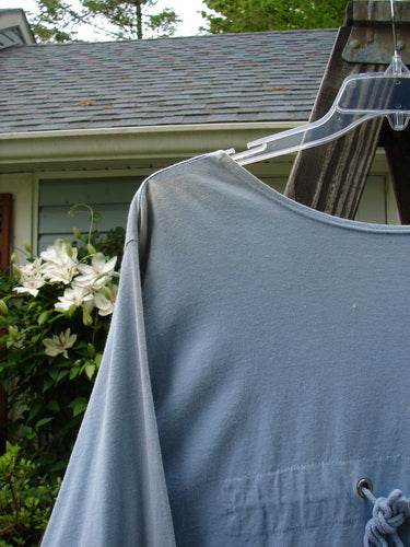 1993 Modernismo Cardigan Koi Periwinkle OSFA displayed on a plastic hanger, showcasing rear shoulder pleats, old-time buttons, and drop kangaroo pockets, highlighting its vintage appeal and unique design elements.