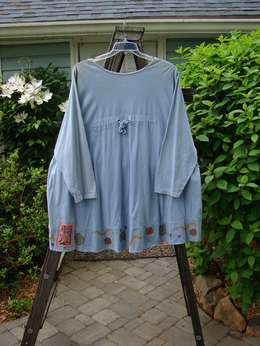 1993 Modernismo Cardigan Koi Periwinkle OSFA displayed on a hanger, highlighting its long sleeves and unique design features like rear shoulder pleats and a classic A-line wide rounded swing.