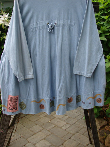 1993 Modernismo Cardigan Koi Periwinkle OSFA on a rack, showcasing rear shoulder pleats, vintage buttons, and unique koi pond design, epitomizing Blue Fish Clothing's creative, vintage style.