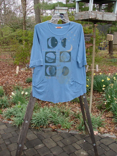 Barclay Banded Sleeve Twinkle Pocket Top Van Gogh Moon Peacock Size 1 displayed on a wooden stand, featuring a rounded neckline, three-quarter sleeves, double exterior pockets, and a moon and stars graphic design.