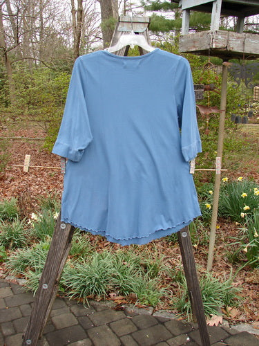 Barclay Banded Sleeve Twinkle Pocket Top Van Gogh Moon Peacock Size 1 displayed on a wooden stand, featuring three-quarter length sleeves, double exterior pockets, and a rounded neckline.