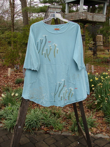 Barclay Three Quarter Sleeved Cafe Pocket Top Long Stem Dusty Aqua Size 1 displayed on a hanger, featuring a floral pattern, feminine neckline, and kangaroo pockets.