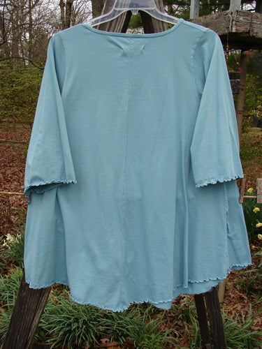 Barclay Three Quarter Sleeved Cafe Pocket Top with a feminine neckline, rounded hemline, and double side-entry pockets, adorned in a long-stem flower theme. Size 1.