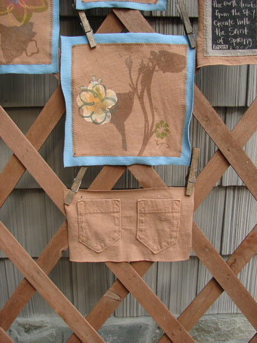 Close-up of The PMU 2000 Spring Floral Pocket Patch Set, featuring intricately designed floral patches mounted on organic cotton, displayed on a wooden lattice.