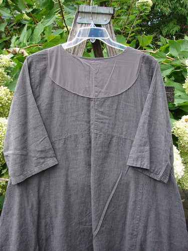 Barclay Linen Cross Over Urchin Pocket Dress Stripe Fig Size 1, displayed on a hanger, features a crossover V-neckline, dropped shoulders, and three-quarter sleeves, set against a leafy green outdoor backdrop.