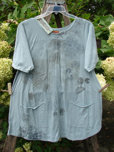 Barclay NWT Seedling Top Dandelion Early Blue Sky Size 1 displayed on a hanger, features front patch pockets, a scalloped hemline, and a botanical print, exemplifying BlueFishFinder's vintage style.