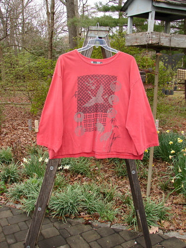 Barclay Long Sleeved Crop Oversized Tee Crane Sherbet OSFA displayed on a clothes rack outdoors, featuring a rounded and rolled neckline with a wide, consistent shape.