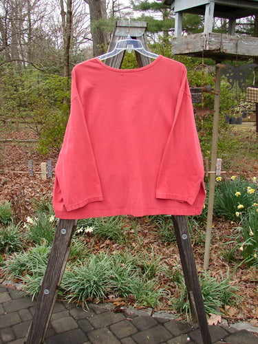 Barclay Long Sleeved Crop Oversized Tee Crane Sherbet OSFA displayed on a wooden rack, showcasing its wide shape and rolled neckline with light wear.