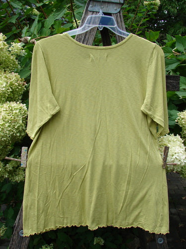 Barclay NWT Modal Slub Simple Tee Frenchtown Sun Gal Citron Size 1 hangs on a clear hanger against a rustic wooden ladder, showcasing its rounded neckline and slight A-line shape.