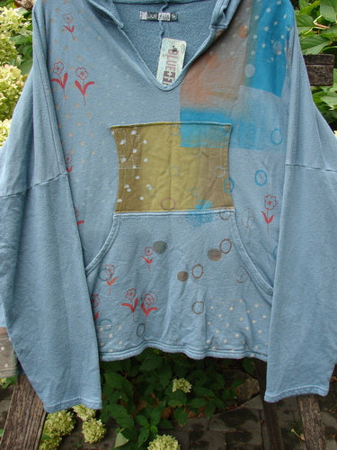 Barclay NWT Fleece Modal Hip To Be Square Hoodie Rain Flower Sea OSFA features a washed teal pullover with a deep V-neck, olive-green kangaroo pocket, and vibrant floral motifs, showcasing unique vintage style.