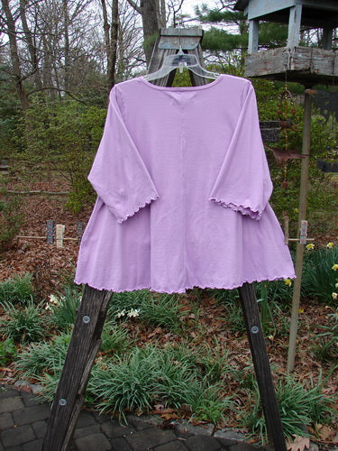 Barclay Three Quarter Sleeved Crop A Lined Tee Sun Guy Mottled Peony Size 1 displayed on a wooden stand, featuring a rounded and rolled neckline with sweet curly edgings.