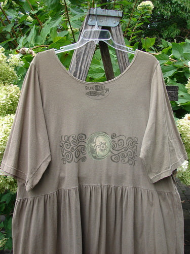 1994 Flower Garden Dress Wind Medallion Bark Size 2, featuring a loose fit with a drop-waist skirt, wide scoop neckline, and decorative medallion motif on the bodice, displayed on a hanger outdoors.