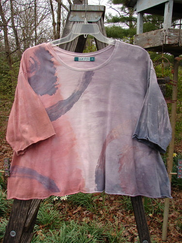 Barclay Three Quarter Sleeved Crop A Lined Tee Wind Mottled Stone Size 2 displayed on an outdoor swing, highlighting its curly edgings, rolled neckline, and flowy wind-themed design.
