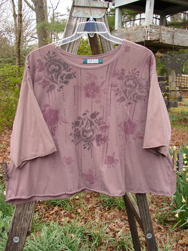 Barclay Three Quarter Sleeved Crop A Lined Tee Victorian Mottled Red Earth Size 2 with floral design, rounded rolled neckline, and sweet curly edgings, displayed against a green grass background.