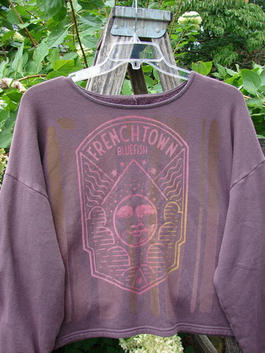 Barclay NWT Fleece Donna Sweatshirt with Frenchtown Logo hangs on a wooden ladder. Features wide sleeves, drop shoulders, and a rounded neckline, embodying Bluefishfinder.com's vintage creative spirit.