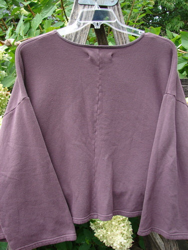 Barclay NWT Fleece Donna Sweatshirt Frenchtown Logo Fig OSFA features a wide neckline, flared sleeves, and a square boxy crop, displayed outdoors on a wooden post.