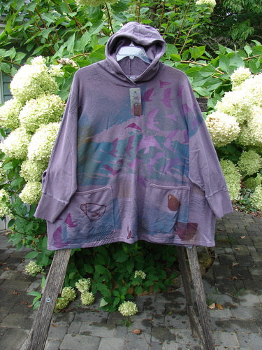 Barclay NWT Cotton Hemp Folklore Hoodie Morning Dove Aura OSFA displayed outdoors on a wooden stepladder, featuring a pullover style, abstract nature print, hood, dropped shoulders, and large front pockets.