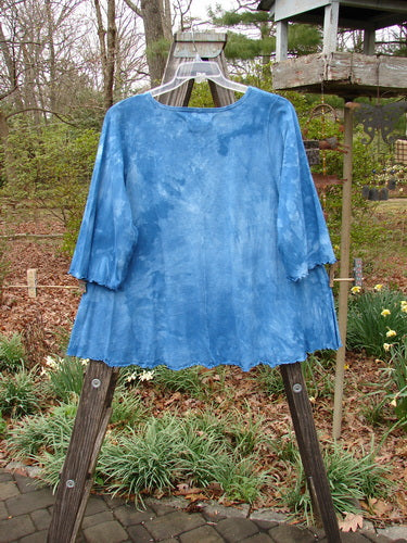 Barclay NWT Three Quarter Sleeved Cafe Tee Leaf Blend Mottled Clear Blue Sky Size 1 displayed on an outdoor swinger, highlighting its A-line shape, rolled neckline, and curly edgings.