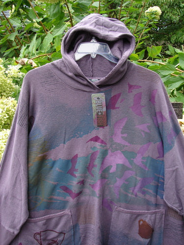 Barclay NWT Cotton Hemp Folklore Hoodie Morning Dove Aura OSFA displayed against foliage, featuring a muted purple-gray shade with pink and blue flocking birds design, swing-tag attached, dual front pockets.