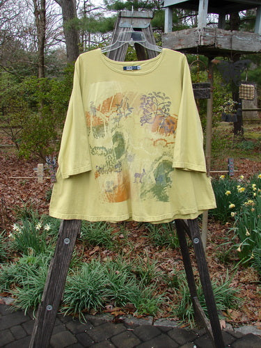 Barclay Three Quarter Sleeved A Lined Tee Garden Friends Mottled Plantain Size 0 hanging on a rack, showcasing a rounded, rolled neckline and sweet curly edgings.