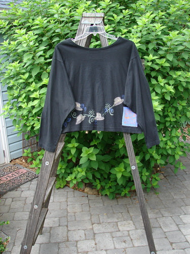 1997 NWT Long Sleeved Crop Tee Top Hat Ebony Size 2 displayed on a wooden ladder, featuring a fun top hat design, drop shoulders, vented sides, and a flattened wider neckline.