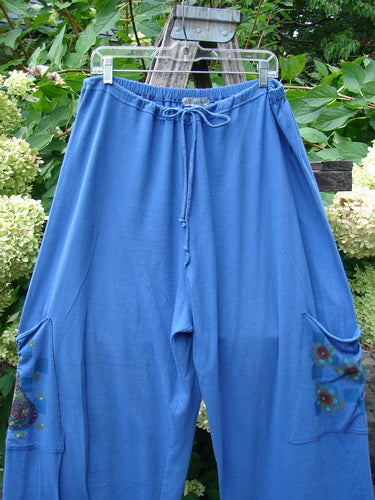 Barclay Drawstring Double Pocket Pant Shop Purse Skylark Size 2, featuring a relaxed fit with elastic waistband, wide legs, and decorative painted pockets, hanging outdoors amidst lush greenery.
