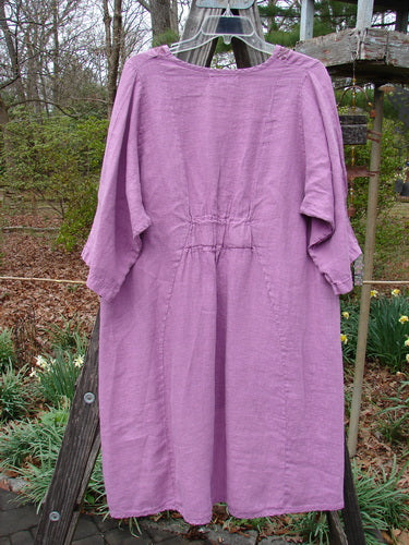 Barclay NWT Linen Poset Tunic Dress Clover Field Orchid Size 0 displayed on a clothes rack, showcasing its flowy figure-eight shape, oval neckline, and exterior drop front pockets.