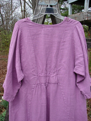 Barclay NWT Linen Poset Tunic Dress Clover Field Orchid Size 0 displayed on a clothes rack, showcasing its flowy figure-eight shape, oval neckline, and almost three-quarter length sleeves.