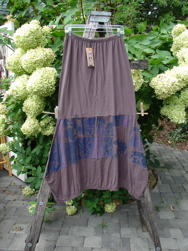 Barclay NWT Sprig Skirt Grid Garden Brown Sparrow Size 0 features a taupe maxi skirt with a diagonal blue panel, displayed on a wooden ladder amidst a lush garden, exemplifying vintage Blue Fish style.